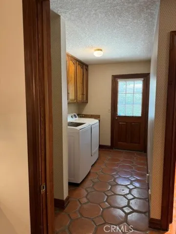 Laundry room off of kitchen has a door to garage & one to side yard