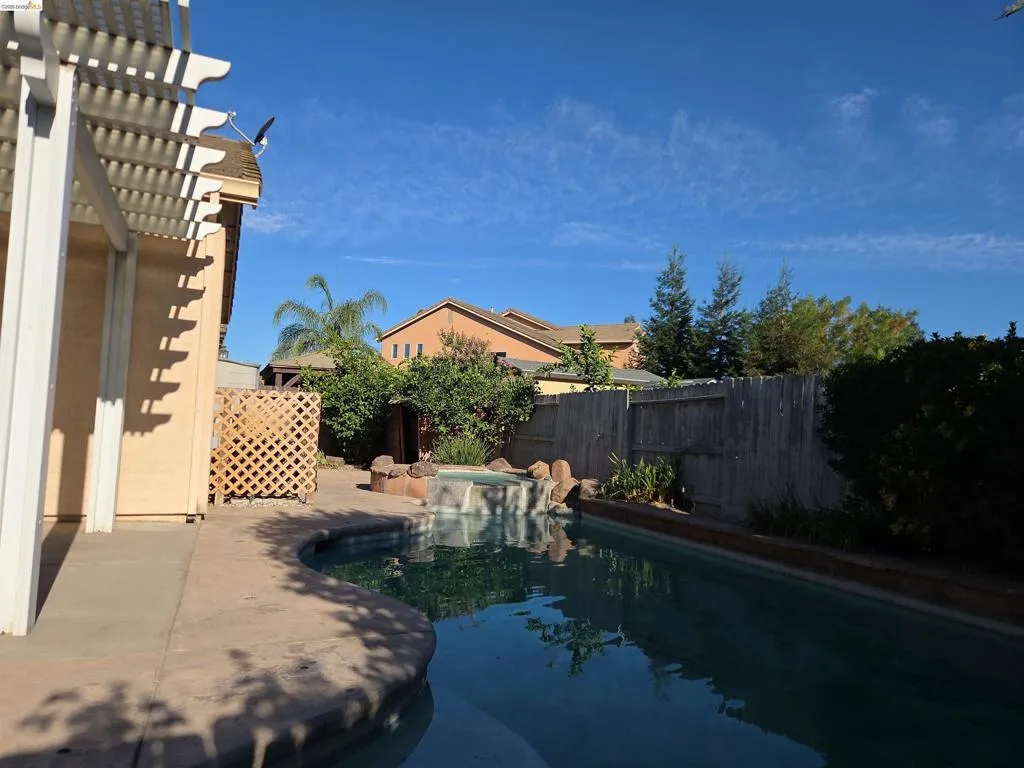 Backyard featuring a freeform swimming pool with a spa and rock waterfall