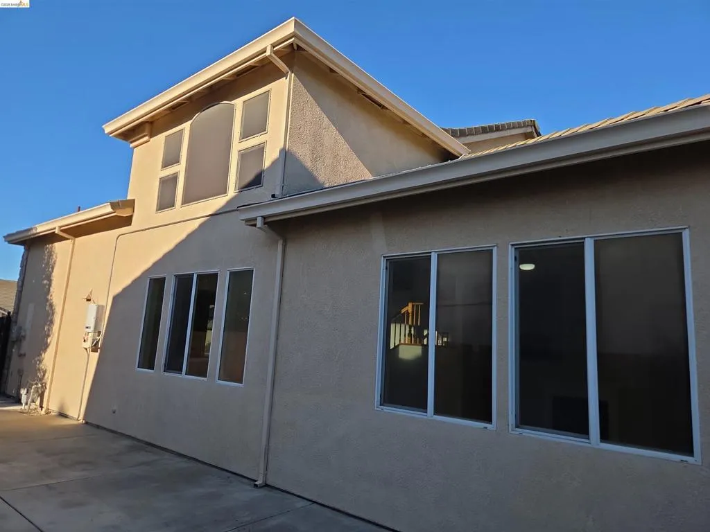 Light-toned stucco exterior with multiple window configurations