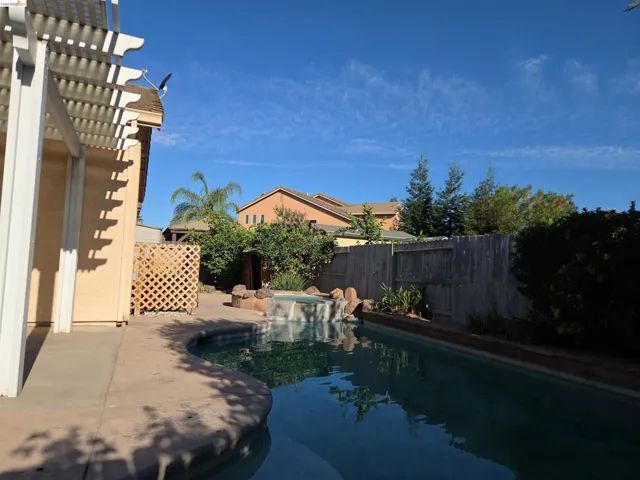 Backyard featuring a freeform swimming pool with a spa and rock waterfall