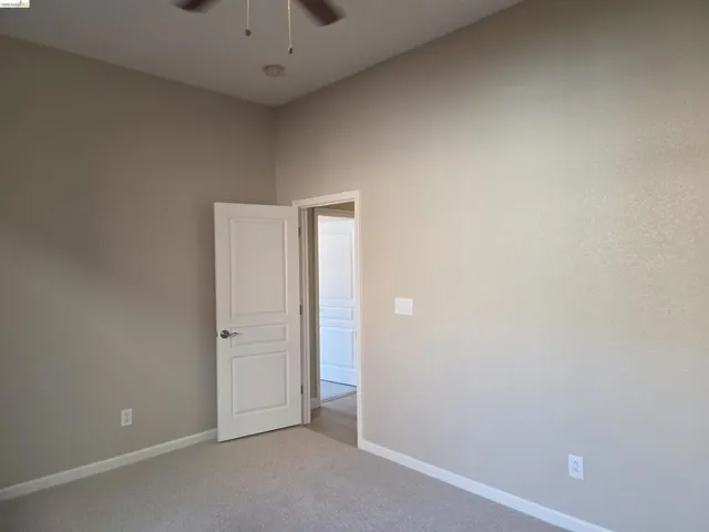 Bedroom featuring neutral carpet flooring, light-toned wall paint, and white trim