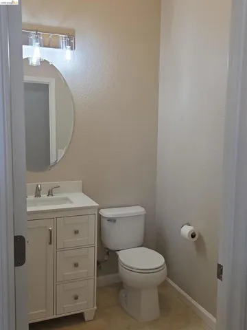 Compact bathroom featuring a white vanity with paneled drawer fronts, a white sink, and a chrome faucet