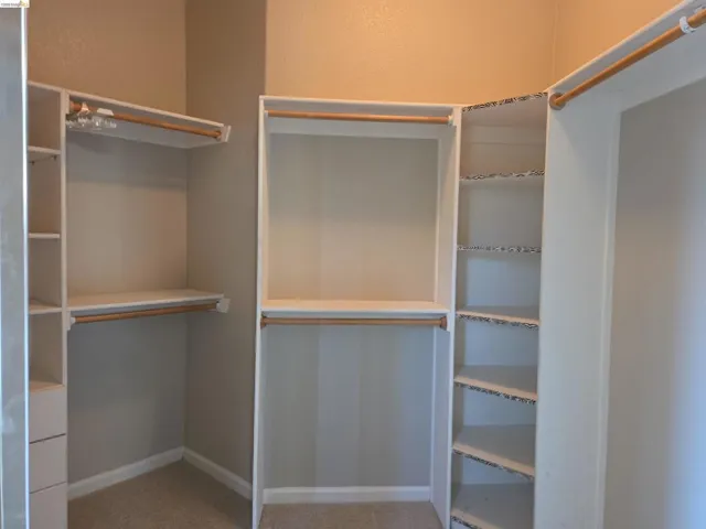Custom built-in closet system with multiple hanging rods, shelving units, and integrated drawers