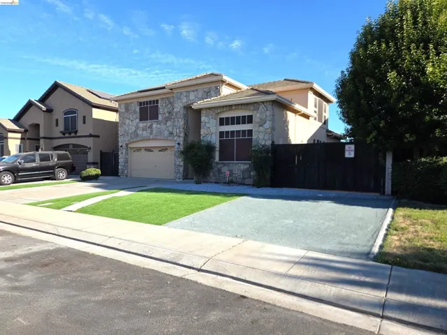 Stone facade residence featuring a two-car garage with an automatic door