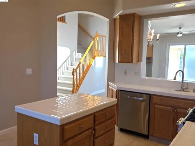 Kitchen island with tile countertop and oak cabinetry