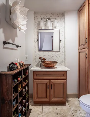 Remodeled powder room with custom cabinetry, quartz surfaces, and a decorative vessel sink.