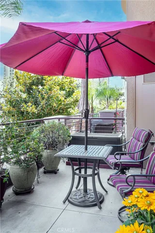 Private patio with outdoor dining area, mature potted landscaping, and room to entertain.