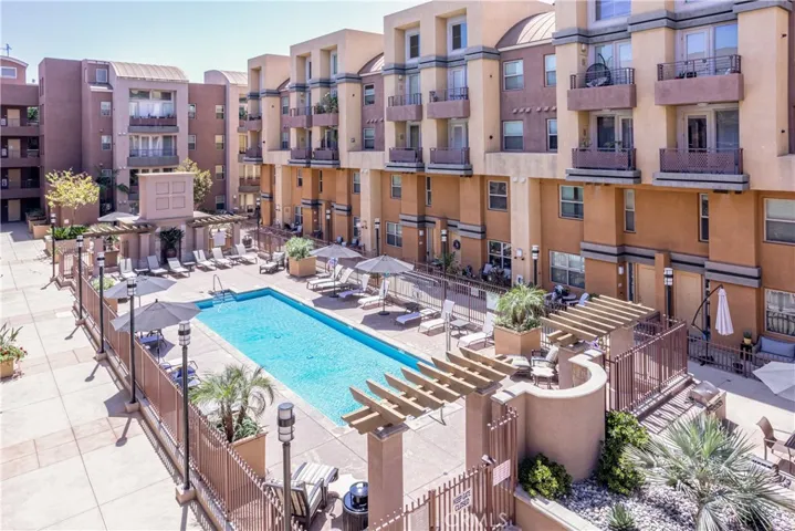 Resort style community pool surrounded by lounge seating and landscaped common areas.