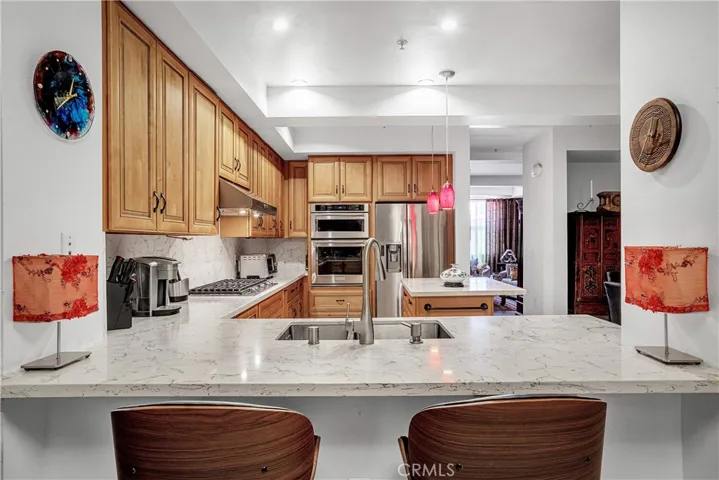 Quartz breakfast bar provides additional dining and entertaining space beside the remodeled kitchen.