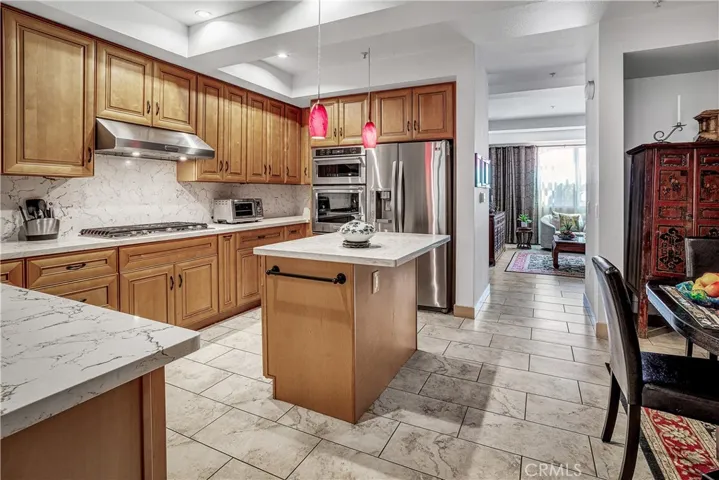 Beautifully remodeled kitchen featuring solid wood cabinetry, quartz countertops, stainless-steel appliances, and a center island.