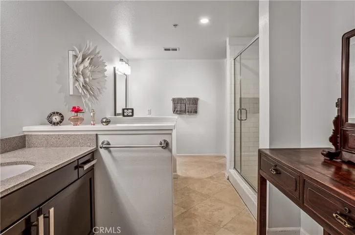Primary bathroom with updated vanity, separate tiled shower, and spacious layout.