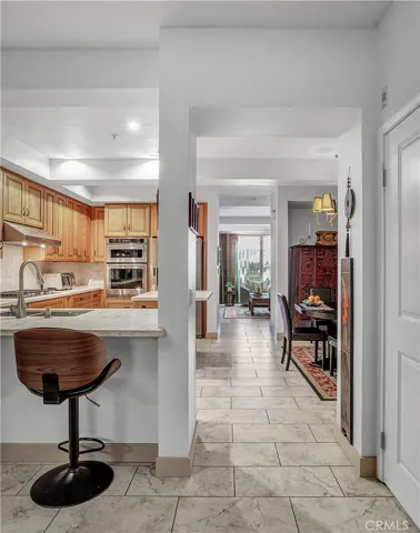 Open main level floor plan with porcelain tile flooring connecting the kitchen, dining, and living spaces.