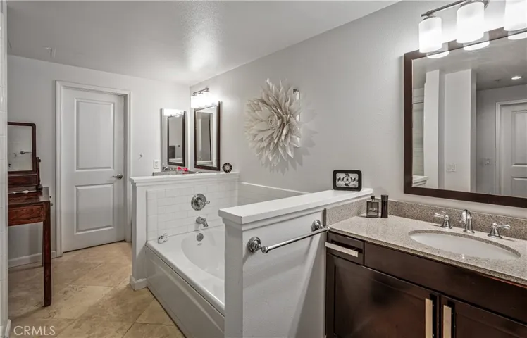 Spacious primary bathroom with soaking tub, separate shower, updated vanity, and abundant counter space.