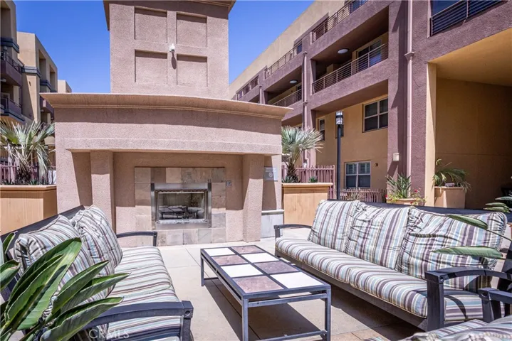 Community outdoor fireplace lounge provides comfortable seating for gathering and relaxation.