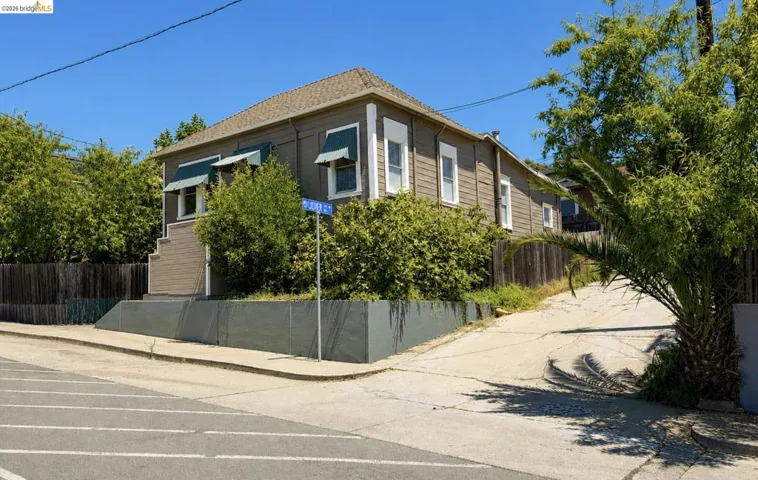 Corner property featuring a stucco and siding exterior with multiple windows