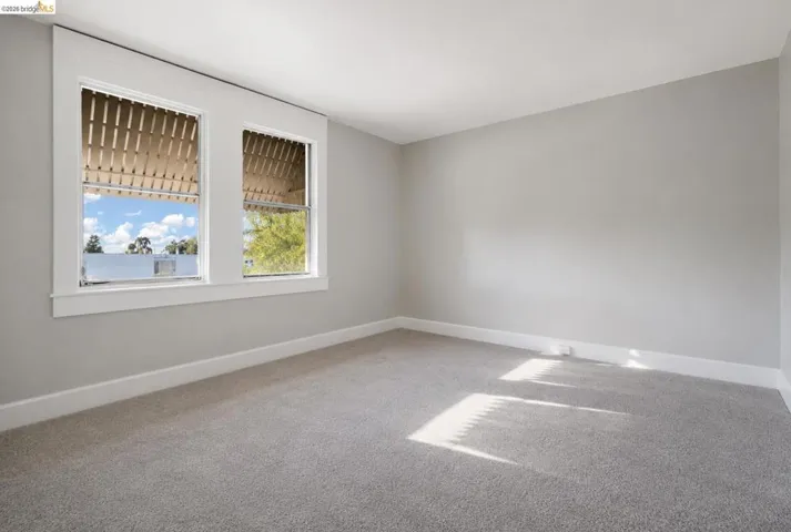 Bright room featuring two large sash windows with exterior architectural detailing