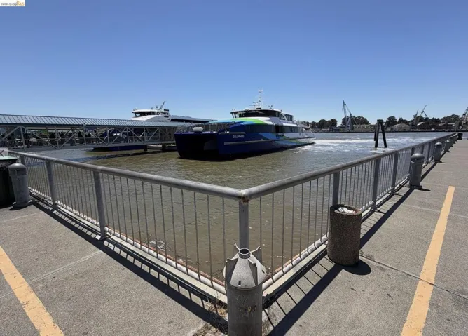 Waterfront concrete pier featuring a metal railing system