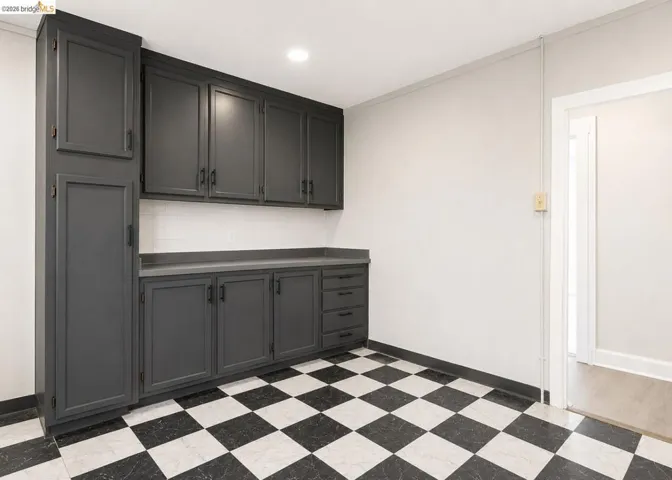 Built-in dark cabinetry featuring extensive storage, a solid surface countertop, and matte black hardware