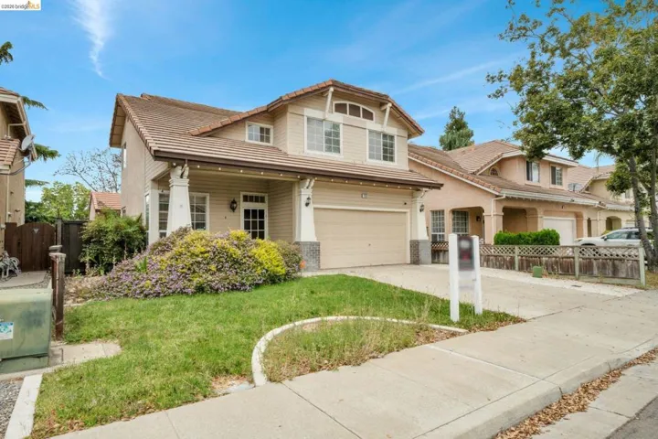 Two-story residence featuring a front entry porch with decorative columns, a two-car garage, and a concrete driveway