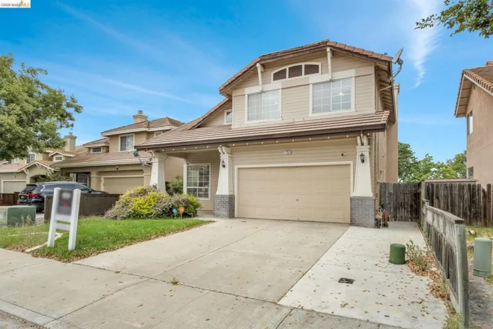 Two-story residence featuring a two-car garage, front landscaping, and a concrete driveway