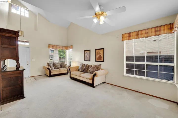 Vaulted ceilings enhance this living room featuring neutral wall tones