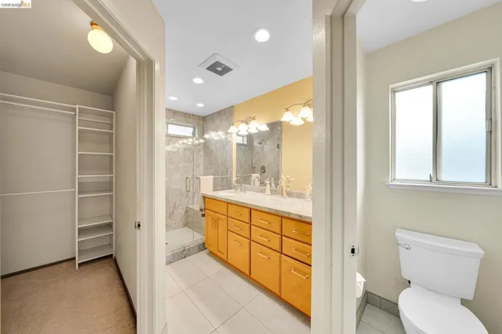 Bathroom featuring a double vanity with light wood cabinetry and a light-toned countertop