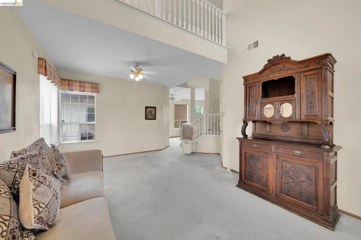 Spacious living area featuring a vaulted ceiling and an upper-level balcony overlooking the room