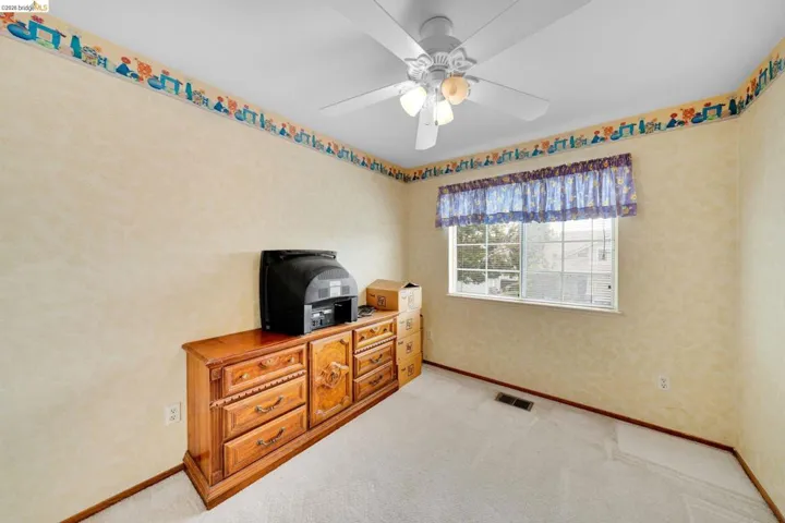 Room with textured wall finish and light-colored carpeting