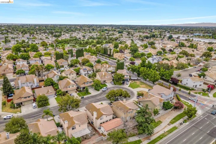 Residential neighborhood featuring single-family homes with pitched roofs, mature trees, and a cul-de-sac street design