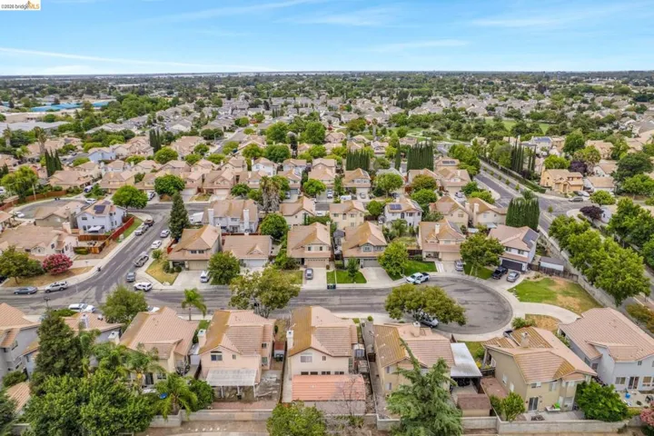 Expansive residential area featuring numerous single-family homes with tan stucco exteriors and tile roofs