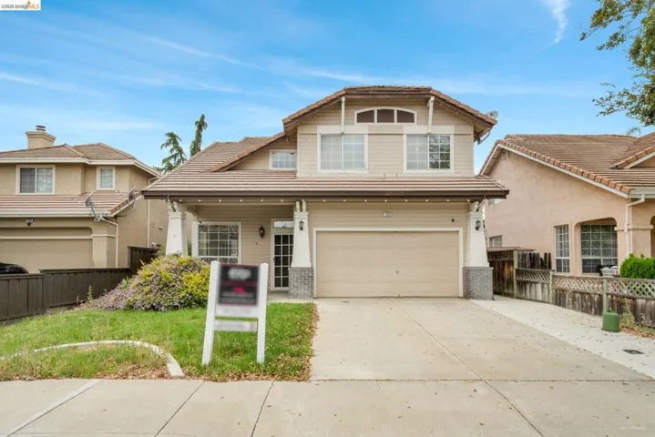 Two-story residence featuring a tile roof, stucco and siding exterior, a two-car garage, and a concrete driveway