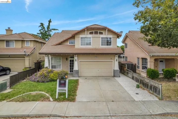 Two-story residence featuring a tile roof, stucco and siding exterior, an attached garage, and a concrete driveway