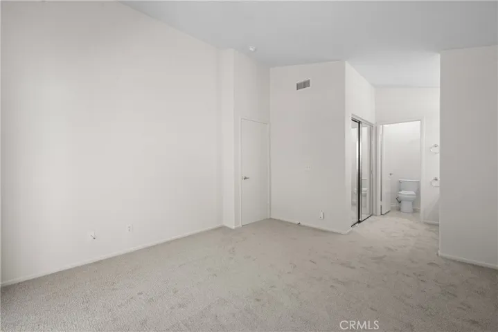 The mirrored doors in the primary suite lead to a walk-in closet.
