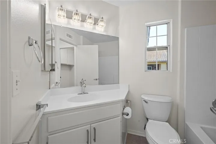 There is a window and new light fixture in the secondary bathroom.