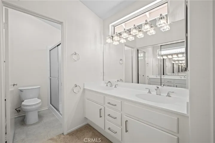 The primary bathroom vanity with new light fixture and window.