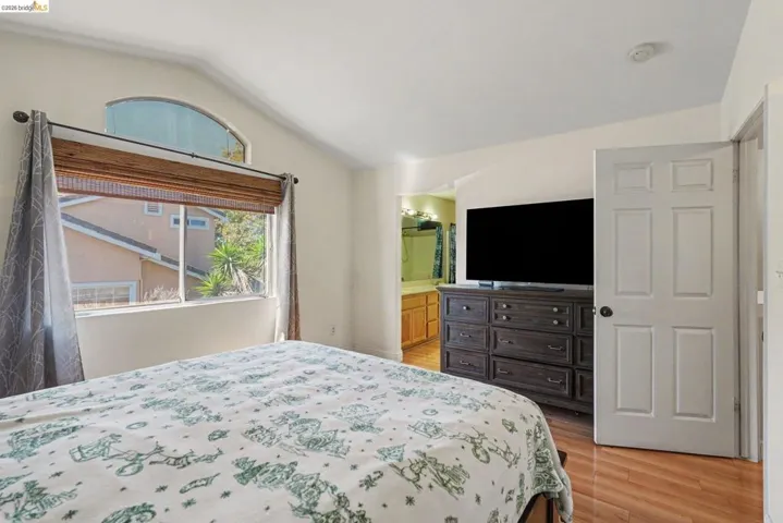 Vaulted ceilings above a large window with an arched transom