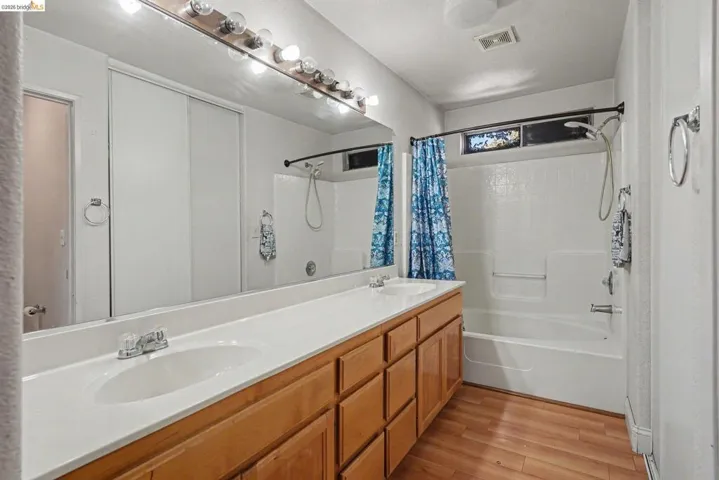 Bathroom featuring a dual vanity with a white countertop and wood-finish cabinetry
