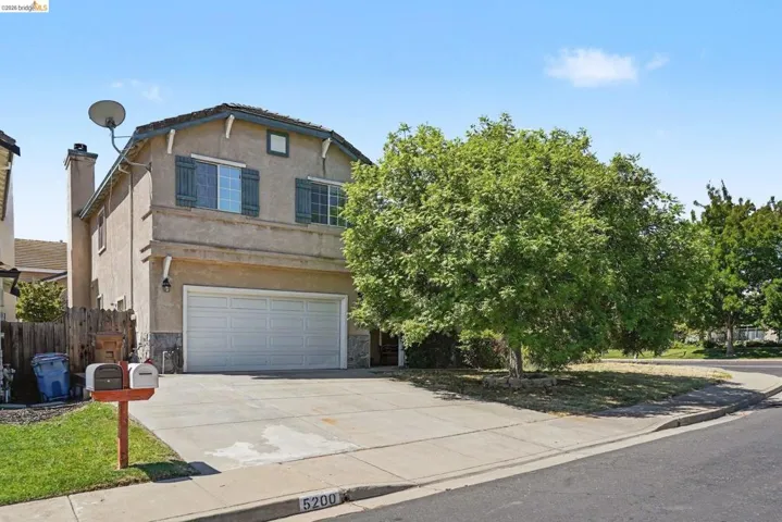Stucco exterior with stone veneer accents and a two-car garage