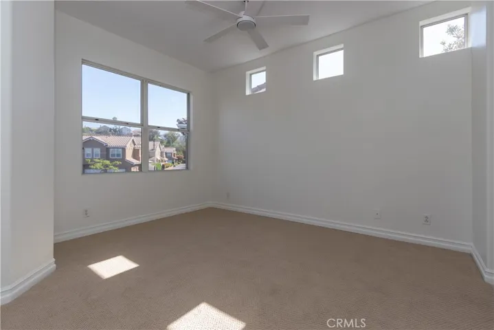 Primary bedroom with great windows, ceiling fan and berber carpet.