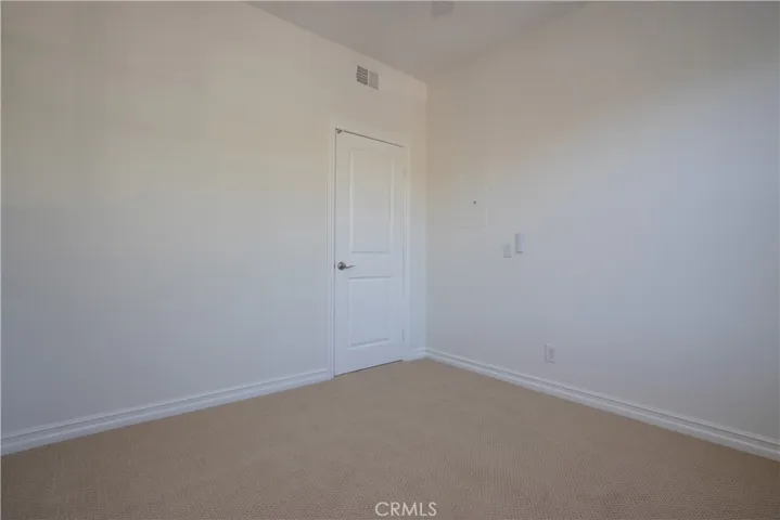Second bedroom with berber style carpet.