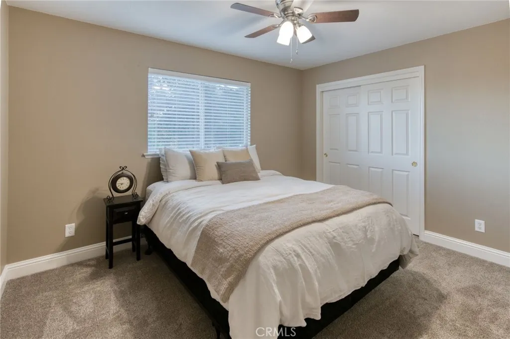 Spacious secondary bedroom comfortably accommodating a queen suite, featuring pristine walls and plush carpets.