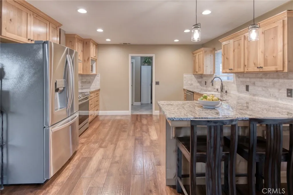 Chef’s kitchen featuring an oversized island, solid wood cabinets, pantry access, and a flowing layout perfect for entertaining.