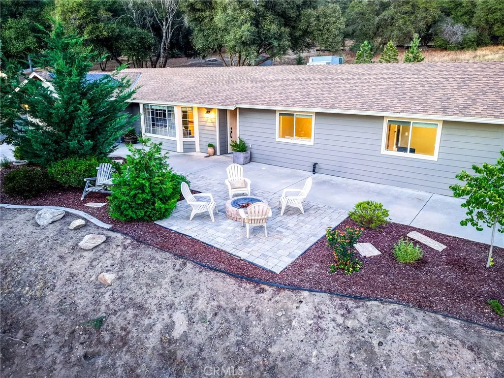 Beautiful landscape design with open-air patio connecting the home directly to nature and outdoor seating.