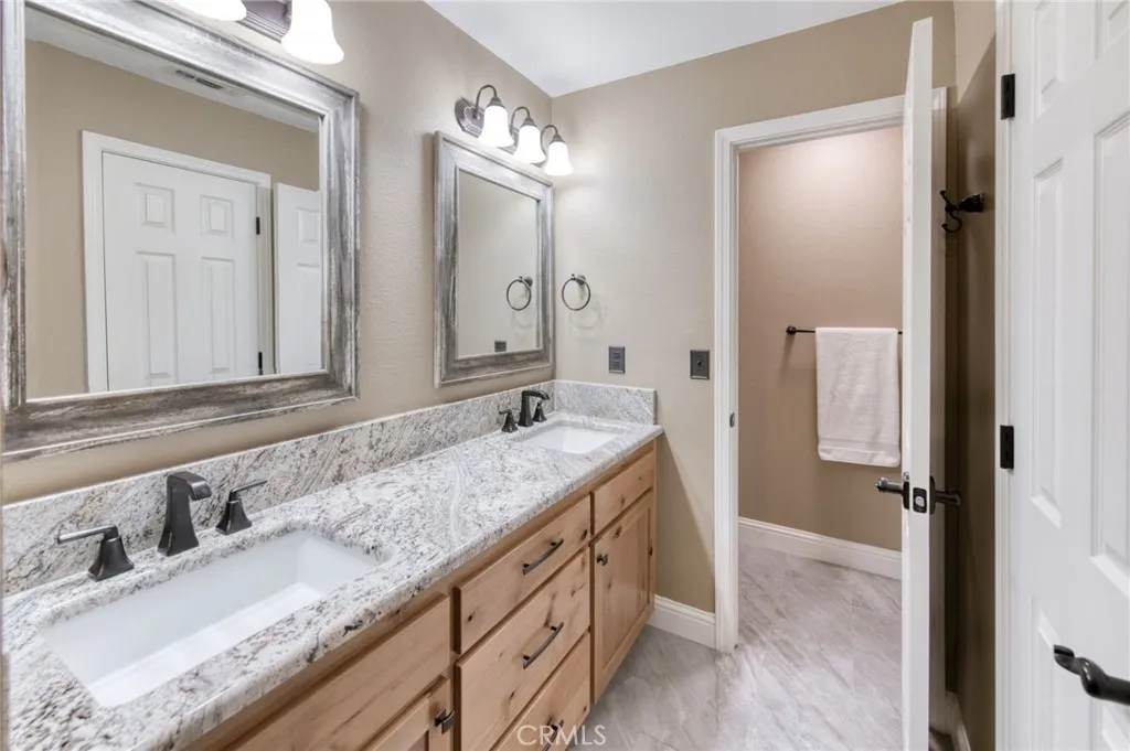 Luxury primary bathroom complete with an extra-wide quartz-style double vanity, large mirrors, and updated hardware.