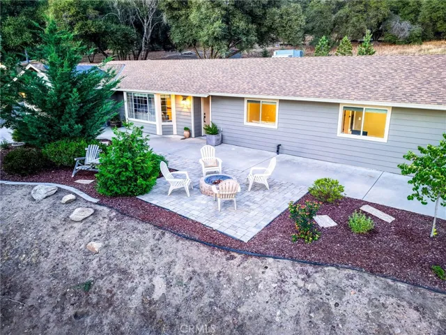 Beautiful landscape design with open-air patio connecting the home directly to nature and outdoor seating.