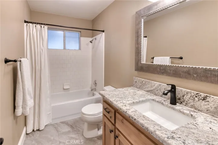 Immaculate second bathroom featuring an updated vanity, bright lighting, and a full shower-tub combination.
