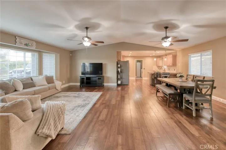Open-concept great room with beautiful engineered hardwood floors, recessed lighting, and dual ceiling fans.