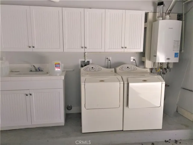 Laundry area with washer, dryer, and utility sink is located in the garage