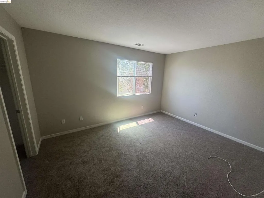 Spare room with a textured ceiling and carpet floors