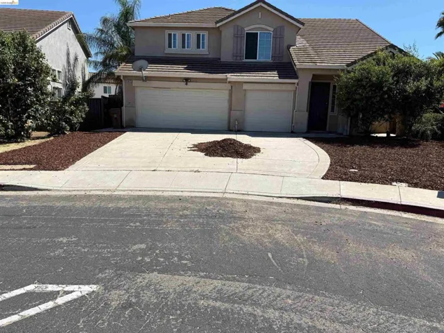 Traditional-style house featuring stucco siding, a tiled roof, an attached garage, and driveway